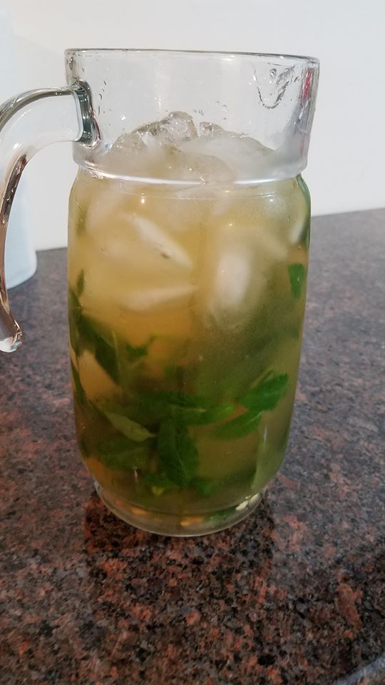 Glass pitcher containing the finished mixed herbal drink.