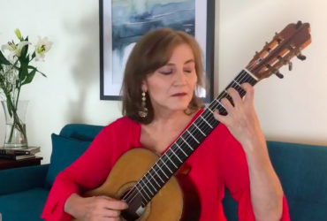 Berta Rojas holding and playing a guitar