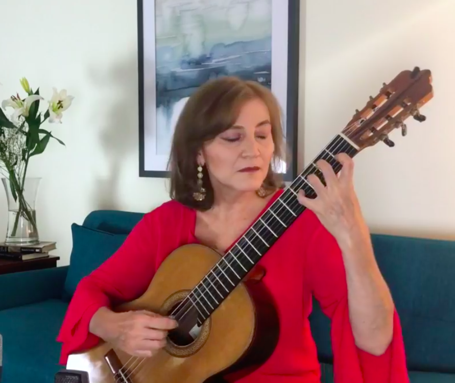 Berta Rojas holding and playing a guitar
